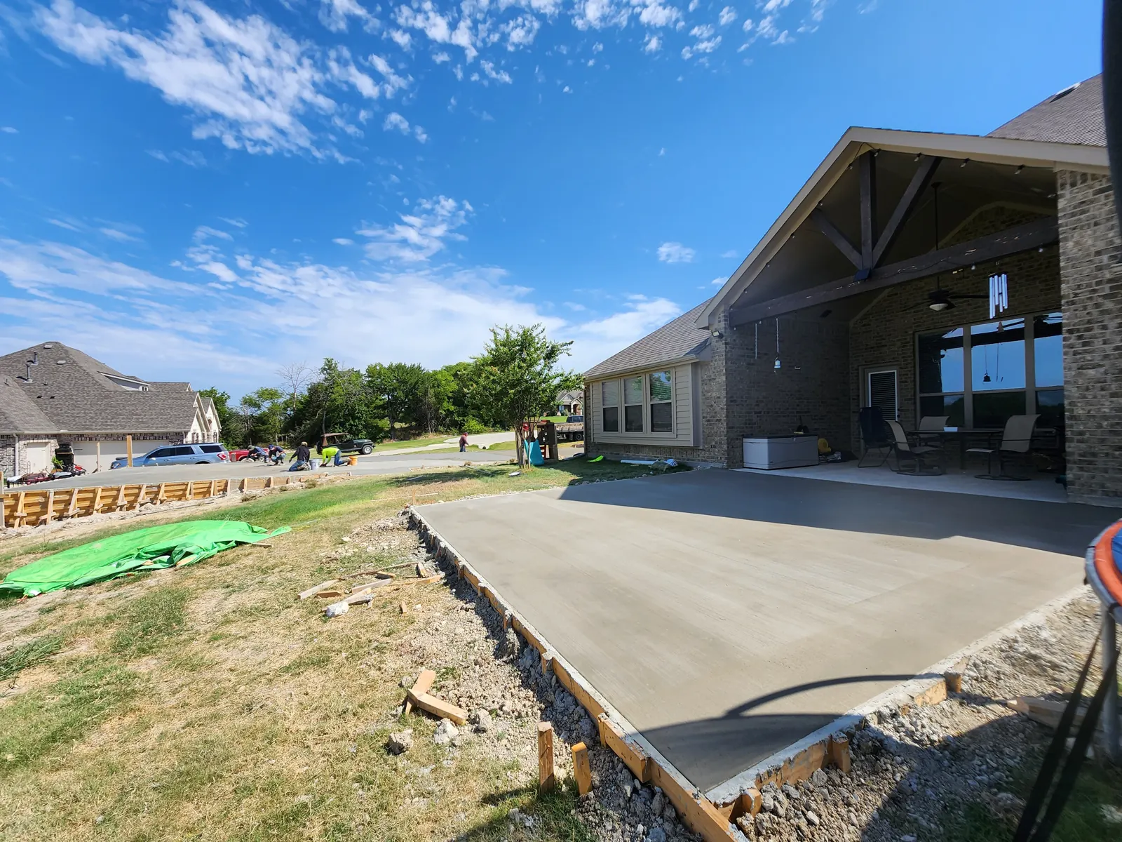 New broom-finish back patio slab beside a covered porch