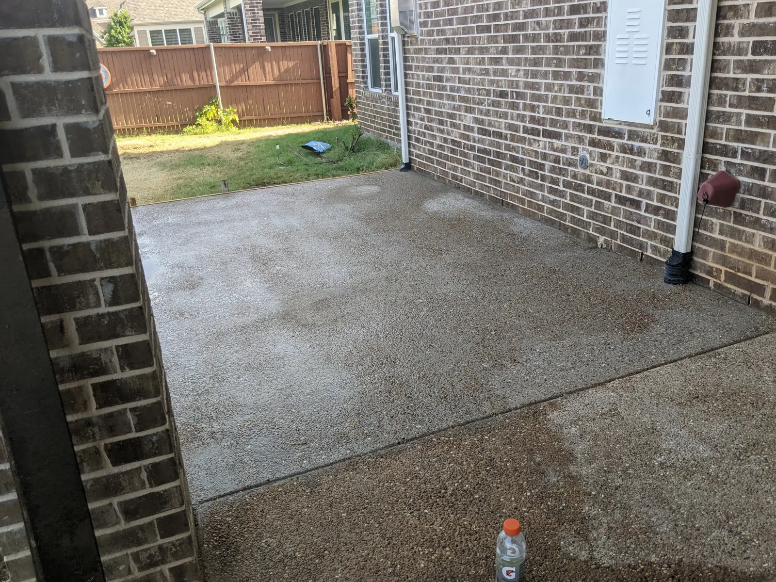 Exposed aggregate patio extension beside a brick home