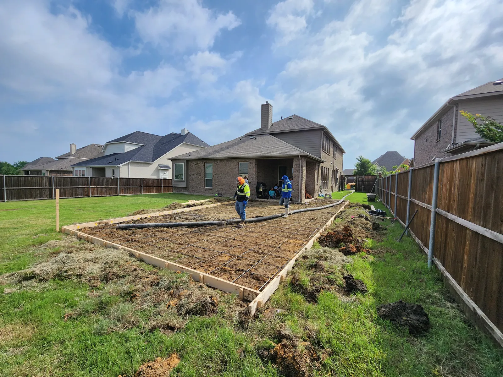 Patio forms and rebar with the pump hose laid out, ready to pour