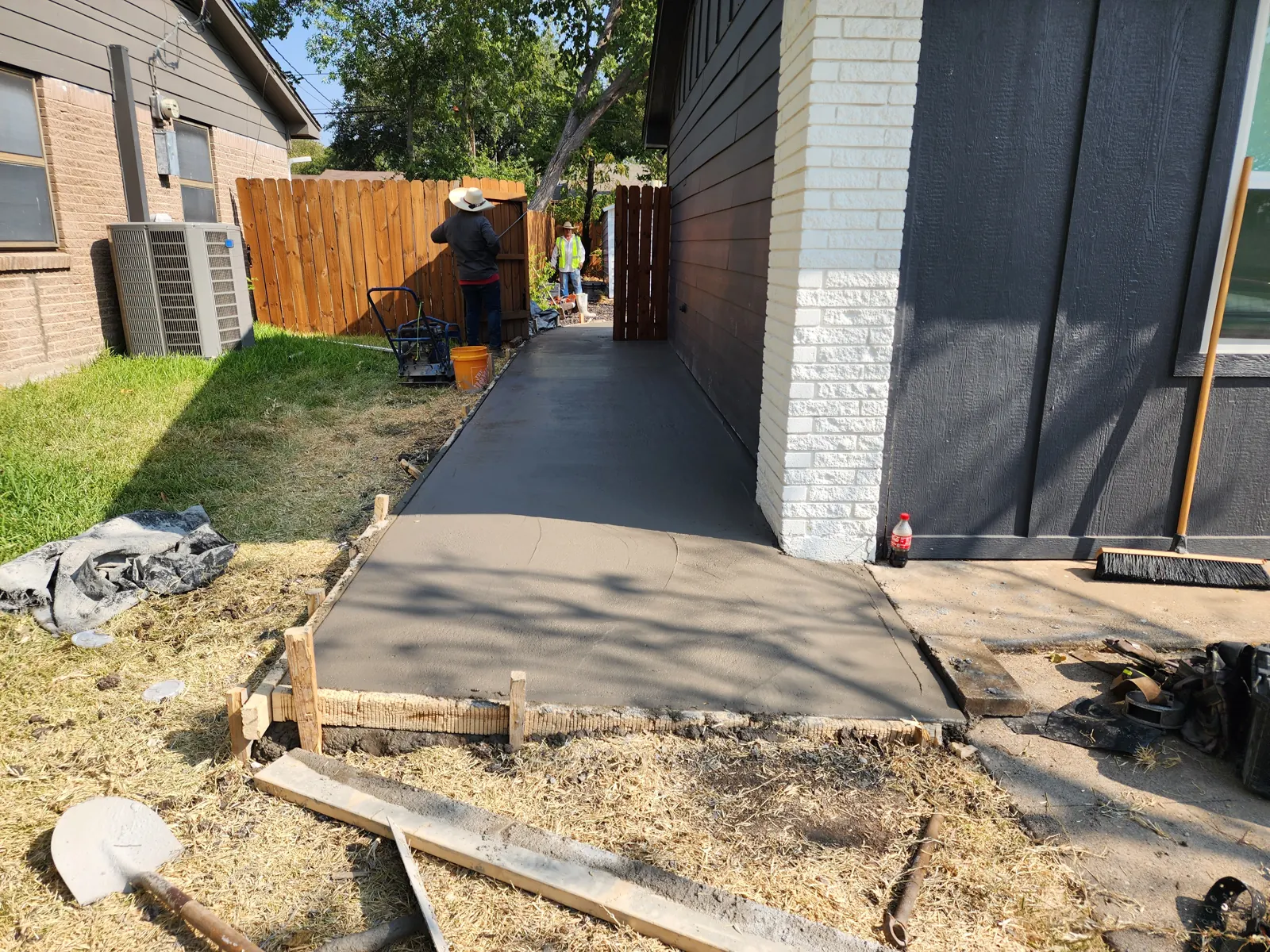 Freshly poured side-yard walkway leading to a gate
