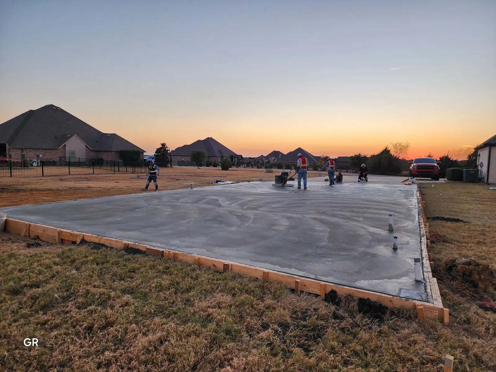 Crew finishing a large slab at sunset