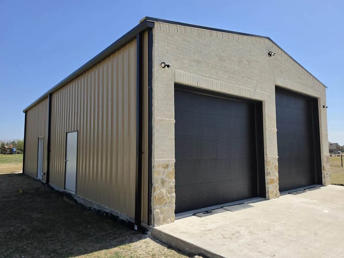 Metal shop with brick and stone front and oversized black overhead doors