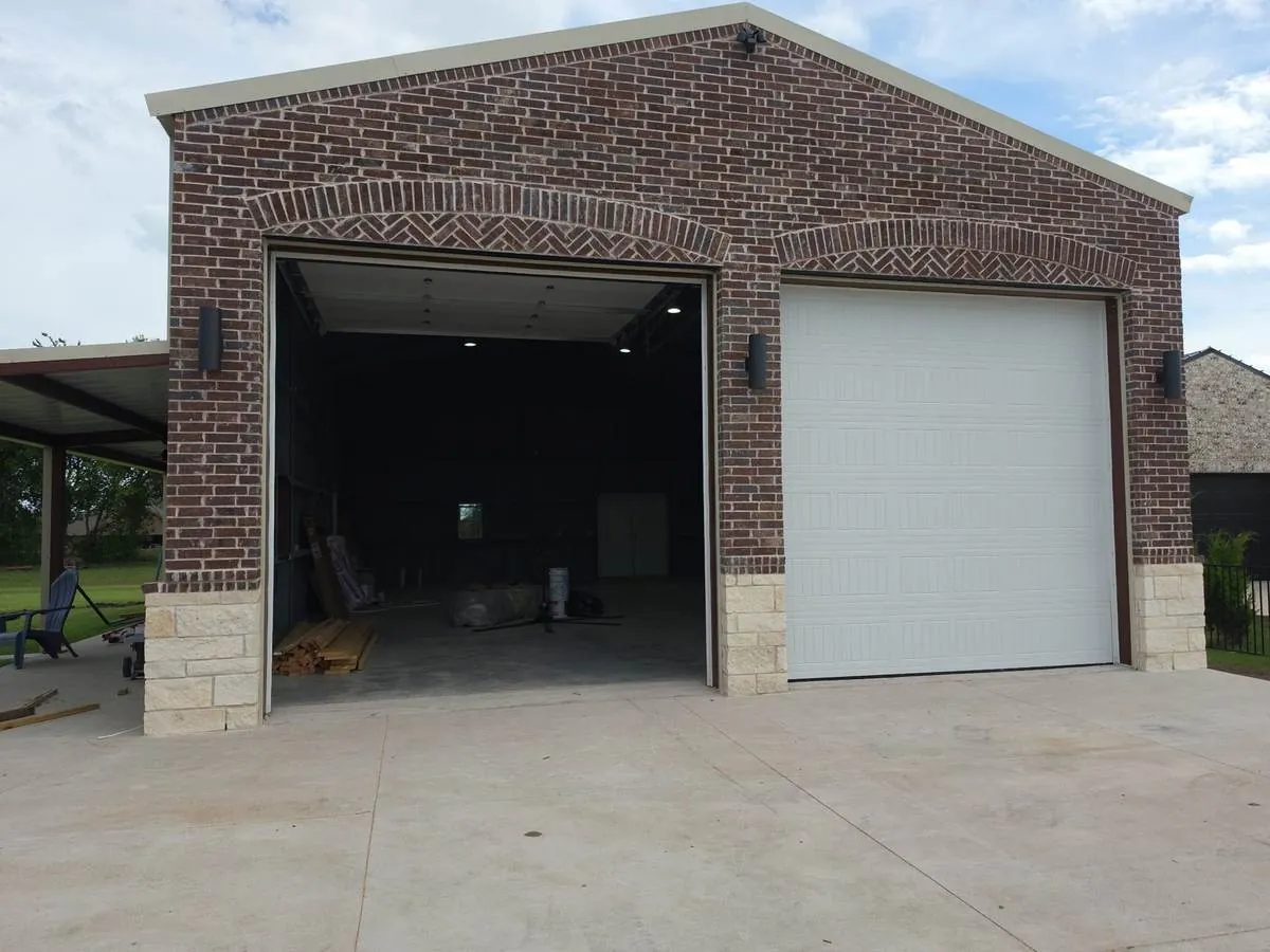 Metal shop with a herringbone brick archway over the bay door
