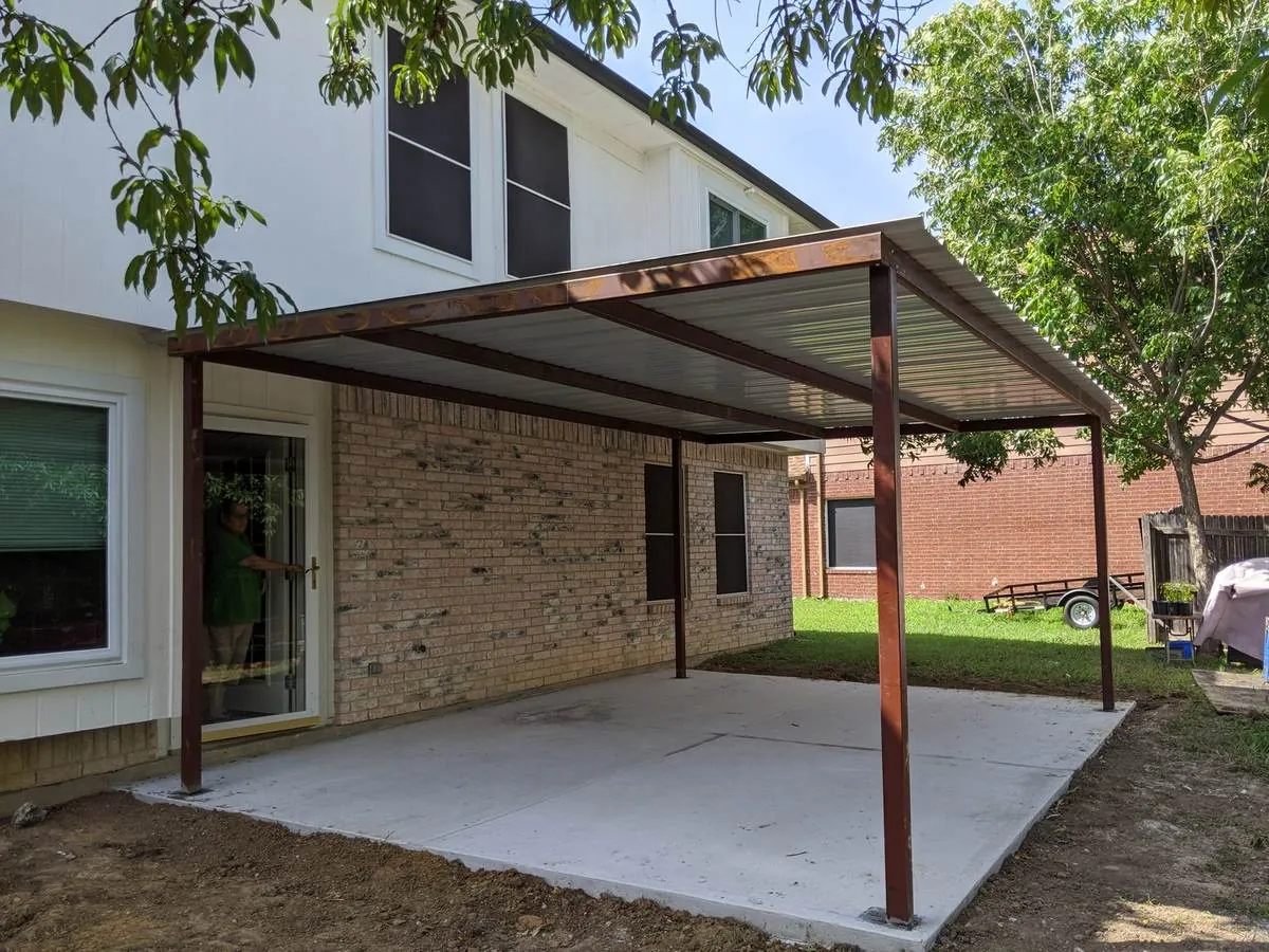 Steel-frame metal patio cover over a concrete slab