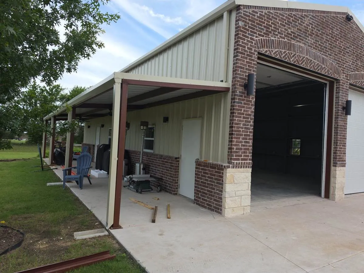 Metal shop with brick and metal siding and a steel-post covered porch