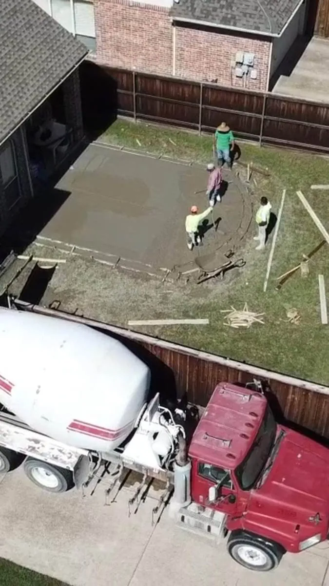 Aerial view of a concrete truck pouring a backyard patio slab