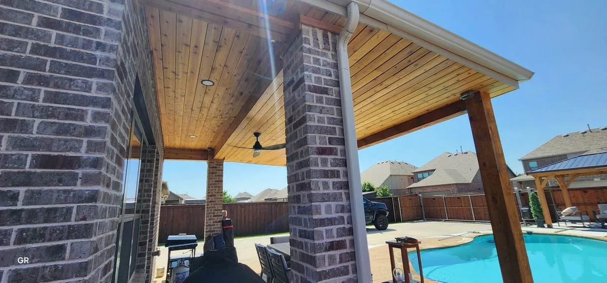 Covered patio with cedar ceiling beside a pool