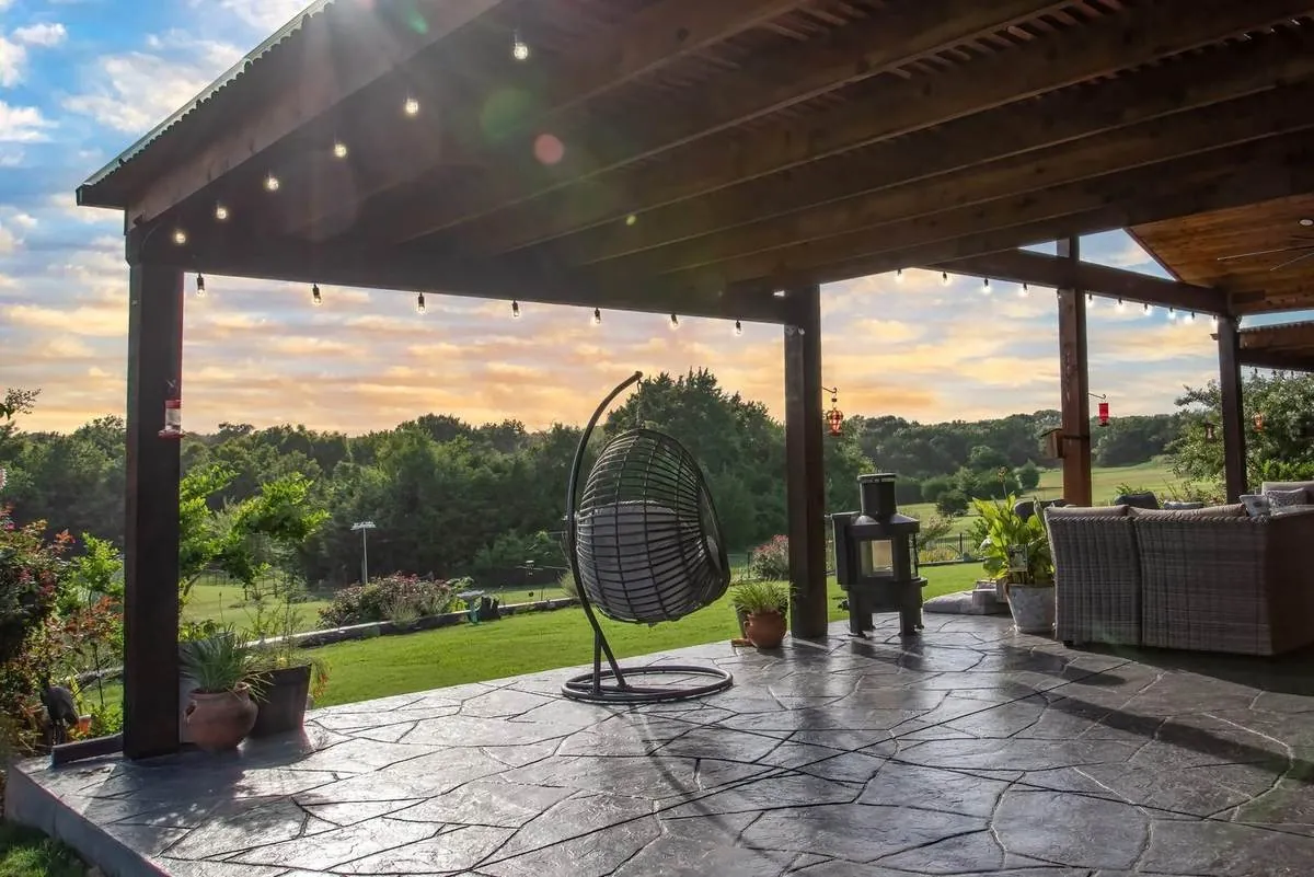 Outdoor living patio at sunset with stamped concrete and string lights