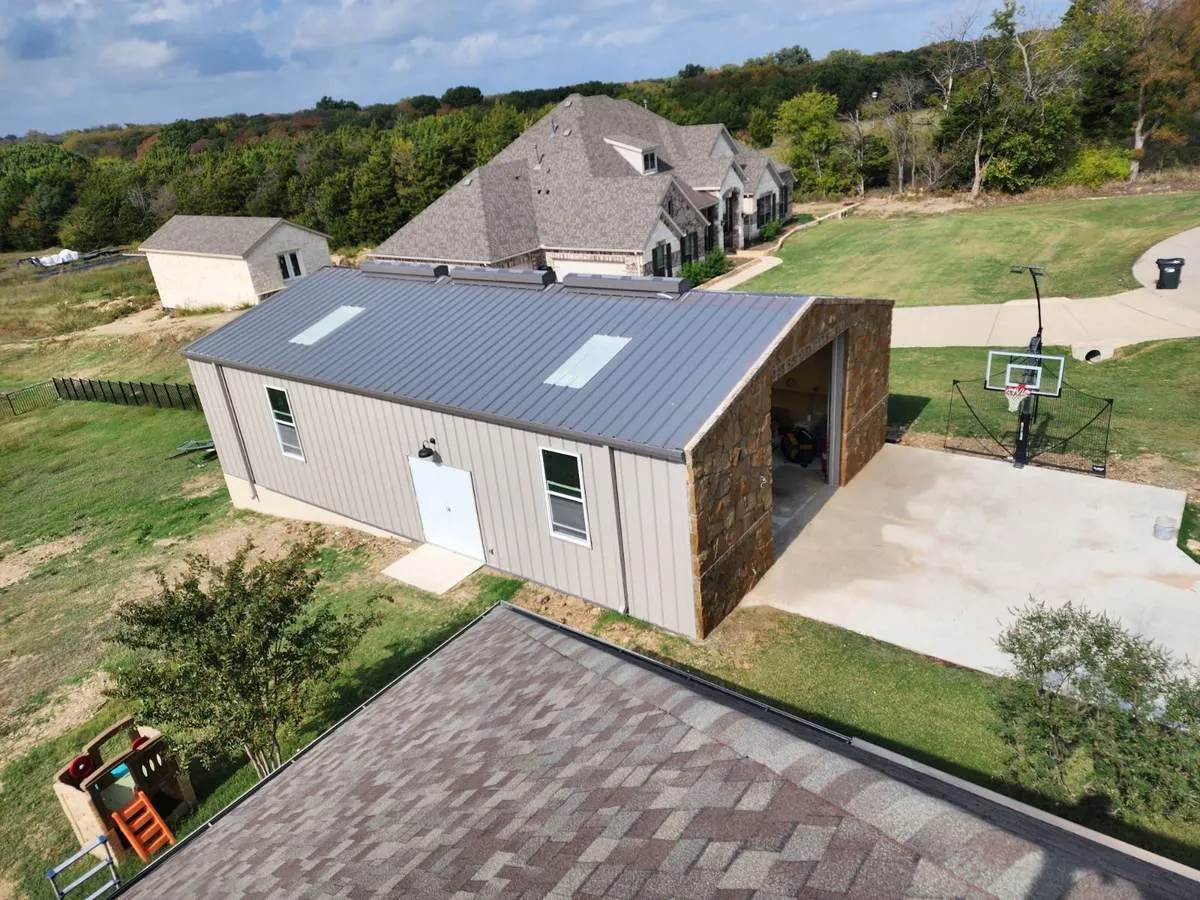 Aerial view of a finished metal shop with standing-seam roof and stone accents
