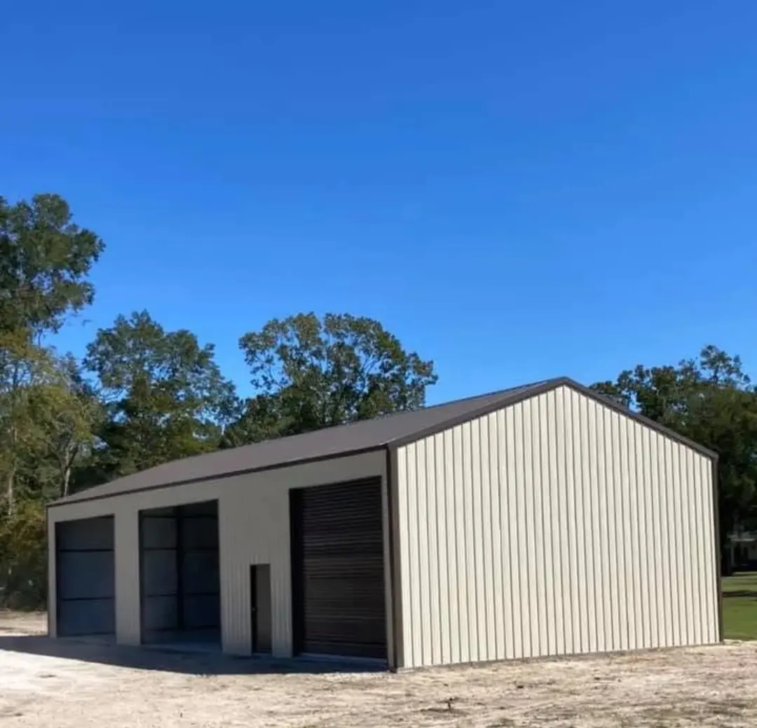 Tan metal shop with three bay doors and a walk door