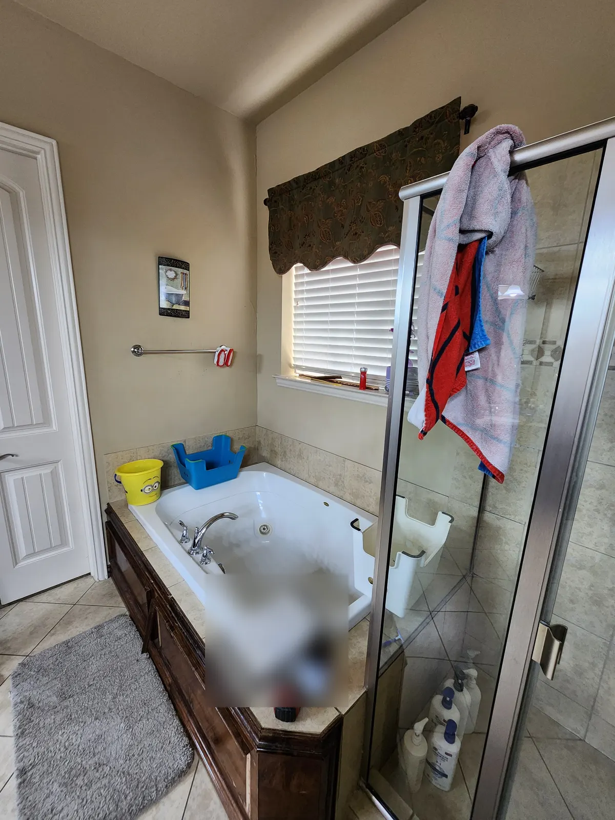 Before: Old jetted tub on a wood deck with a framed glass shower beside it