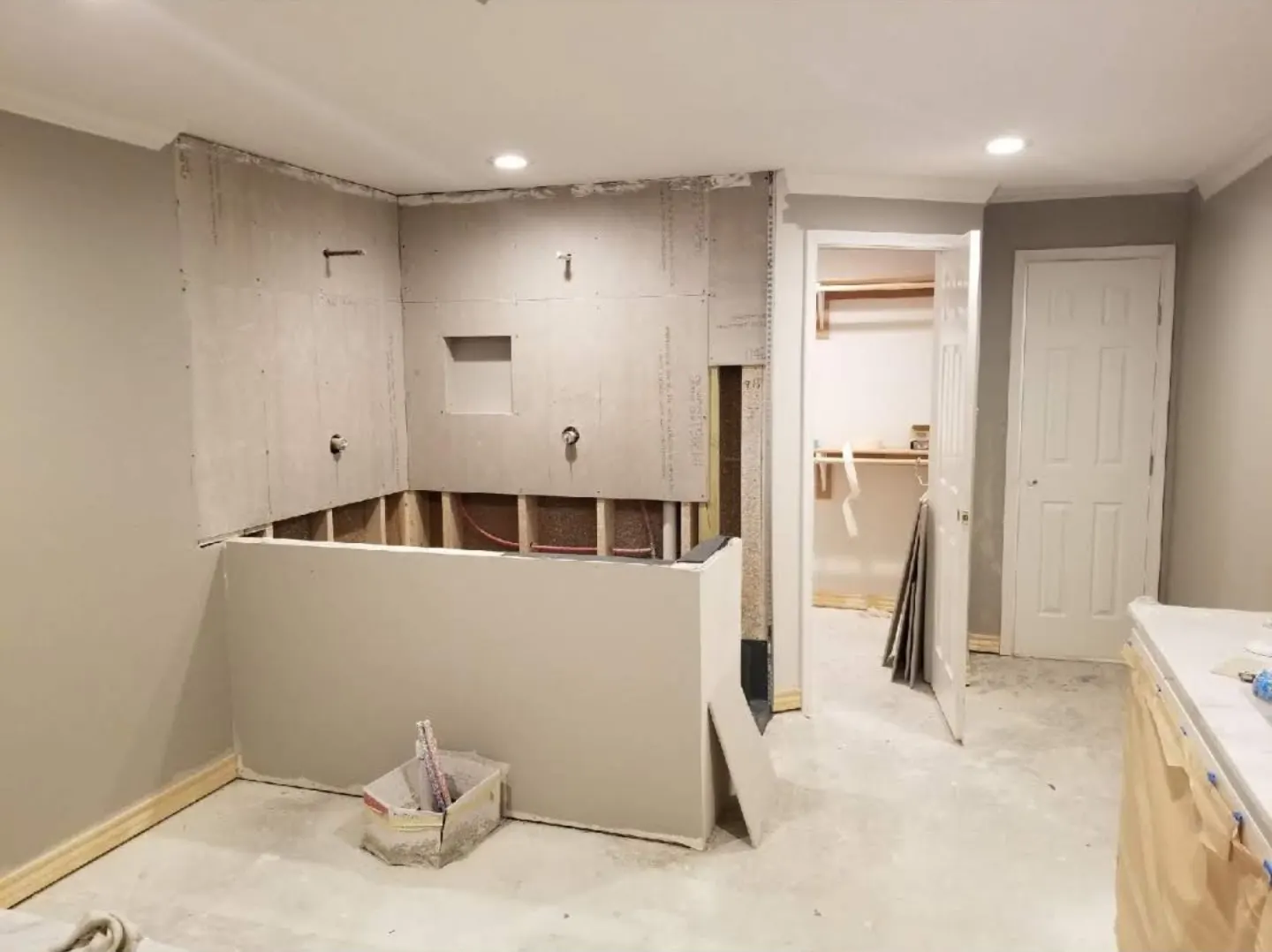 Before: Bathroom stripped to cement board with shower plumbing roughed in