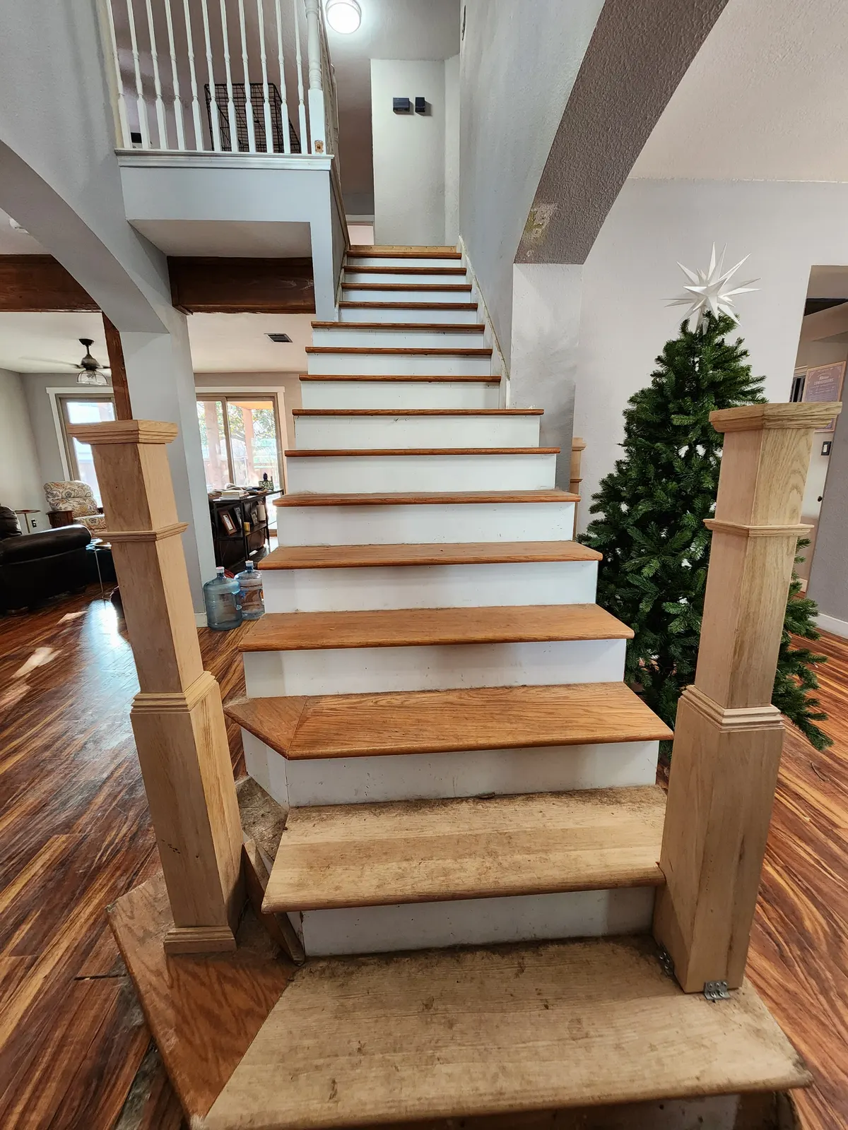 Before: Worn oak stair treads with unfinished newel posts