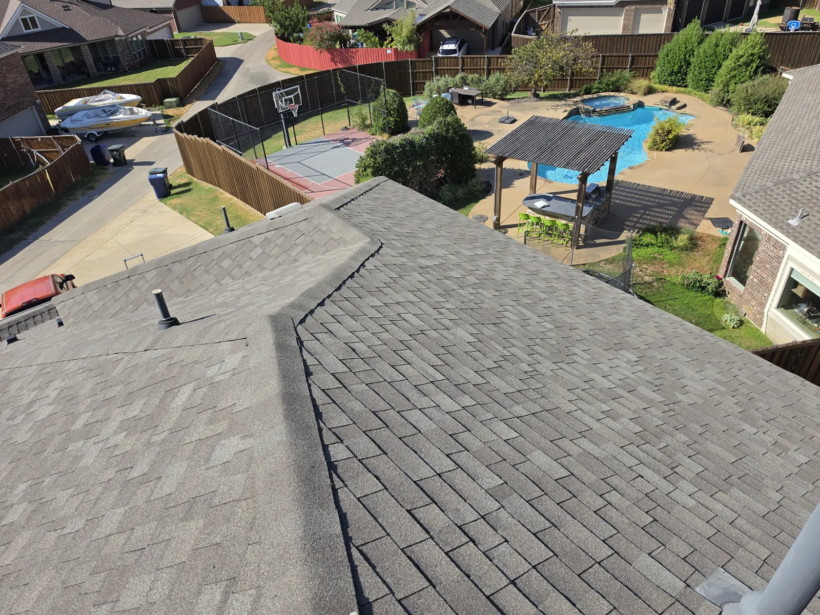 New architectural shingle roof with a clean hip ridge above a backyard pool