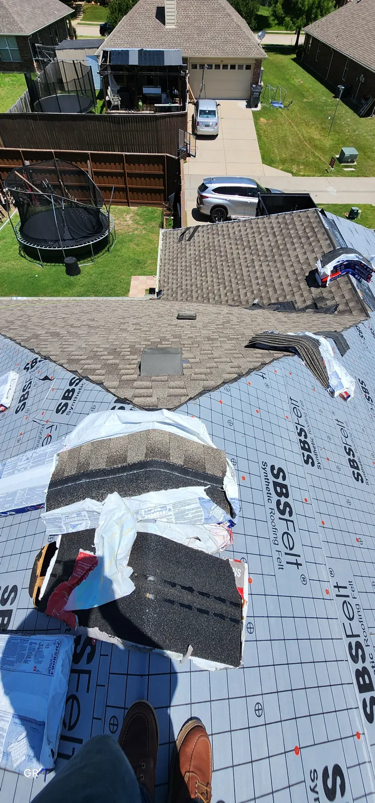 Synthetic underlayment on the roof deck with ridge cap shingles staged